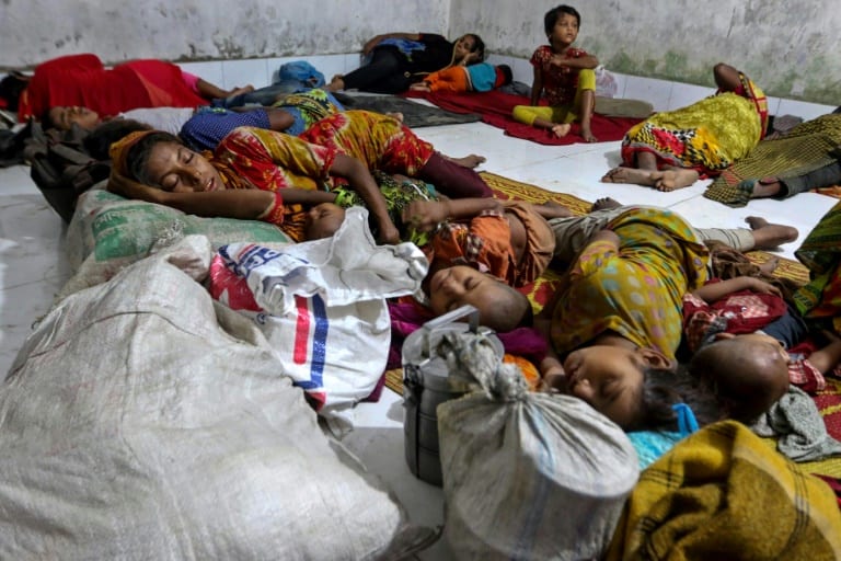 AFP / STR Bangladeshi families evacuated from their coastal villages sleep in a storm shelter as Cyclone Mora approaches