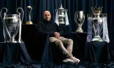 Pep Guardiola poses with some of the major titles he won at Manchester City.
