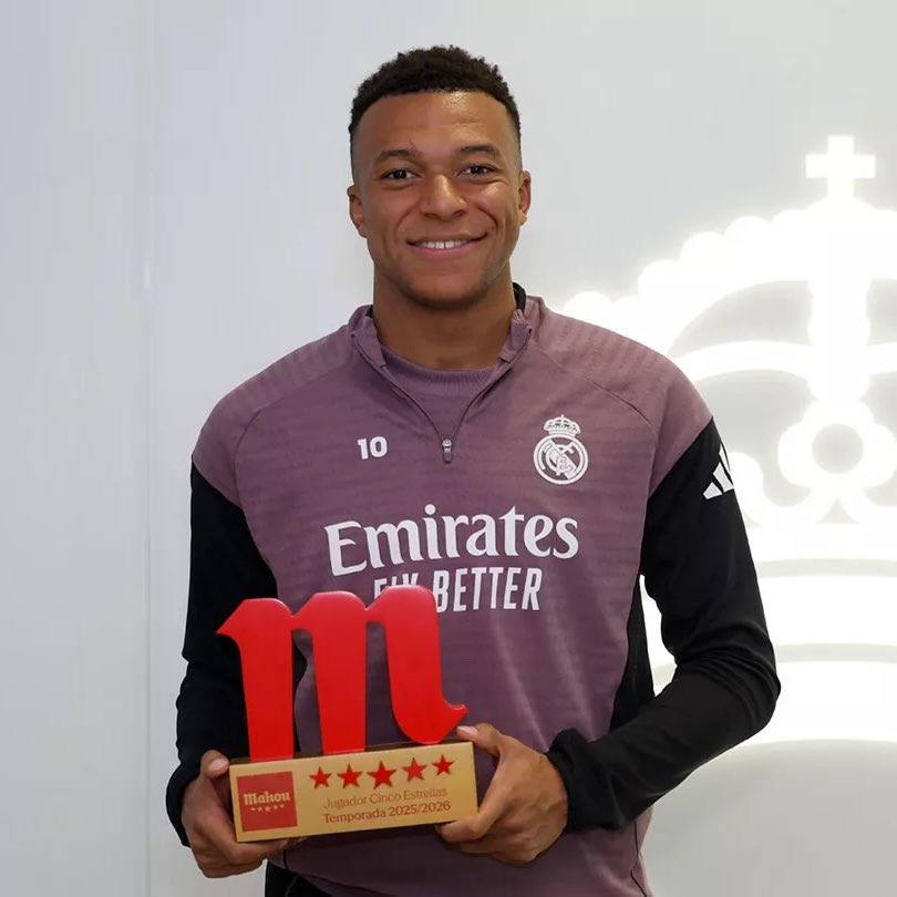 Kylian Mbappé posing with his Real Madrid player of the year award.