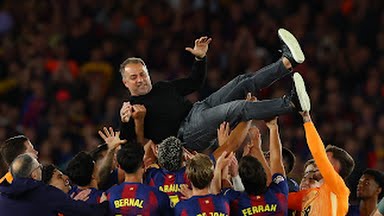 Barcelona players celebrate with coach Hansi Flick after beating Real Madrid to win the 2025-2026 La Liga Title.