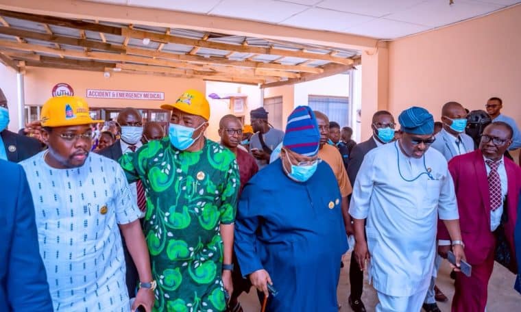 Governor Ademola Adeleke (in blue traditional attire) visits injured victims at the hospital