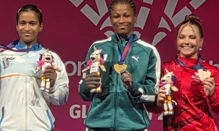 Onome Didih (middle) celebrating her gold win in the women's 53kg weightlifting category.