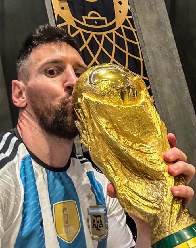 Lionel Messi kissing the World Cup trophy.
